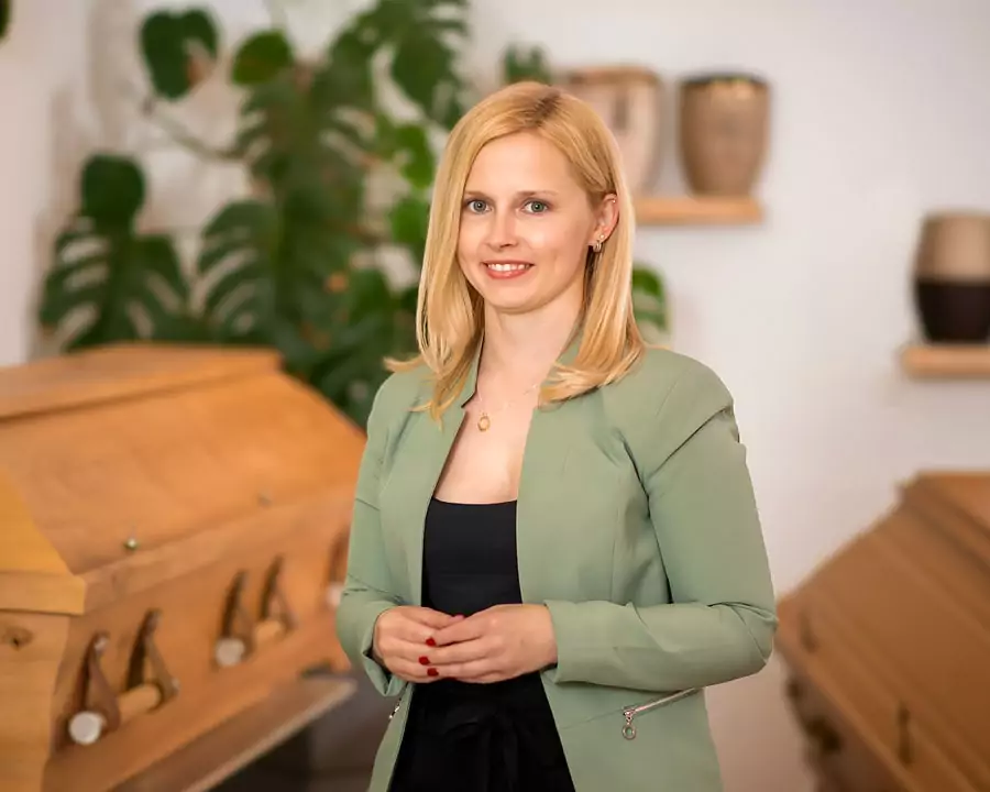 Geschäftsführerin des Bestattungshaus Anita Märtin, Tanja Kvobel, steht im Ausstellungsraum zwischen Särgen und Urnen.